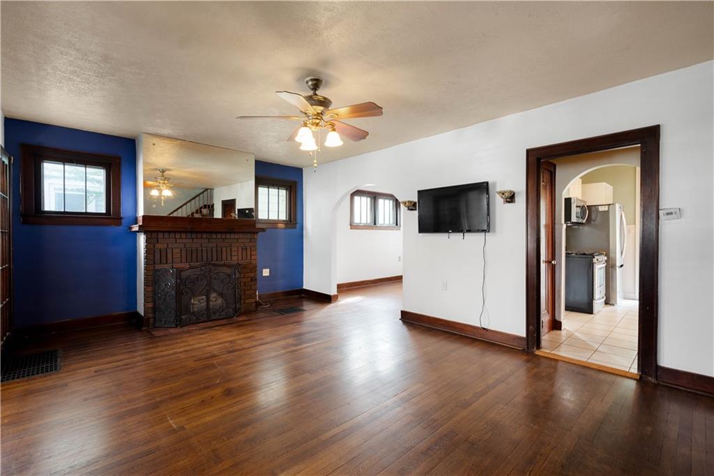 808 5th Avenue Coraopolis, PA 15108 - Photo 6 of 30 a view of a livingroom with a flat screen tv wooden floor and a ceiling fan