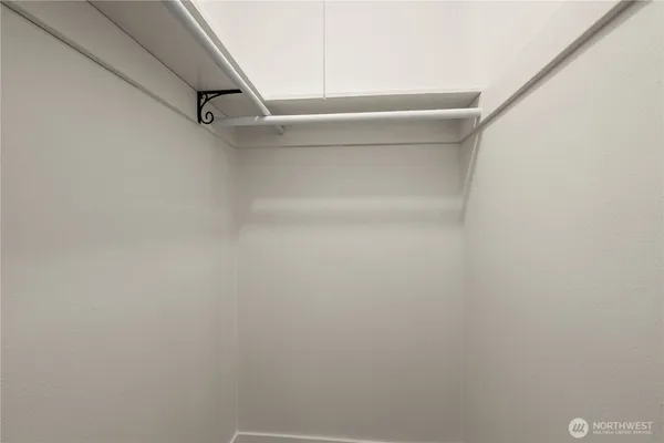 a view of walk in closet with empty racks
