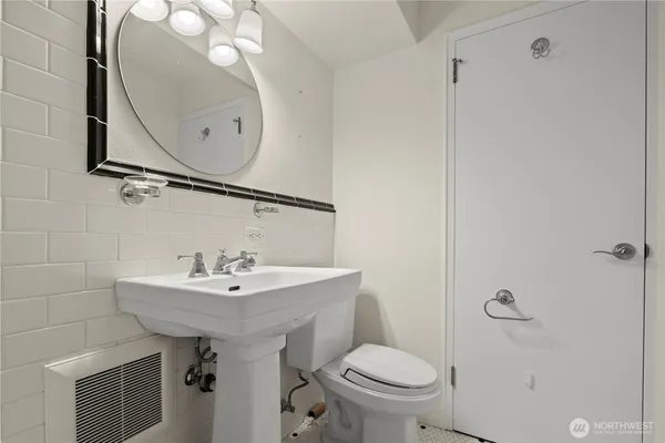 a bathroom with a sink toilet and a mirror