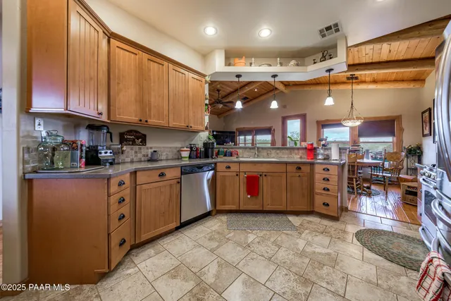 a kitchen with stainless steel appliances granite countertop a sink and a refrigerator