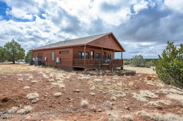 a backyard of a house with large trees and barbeque oven