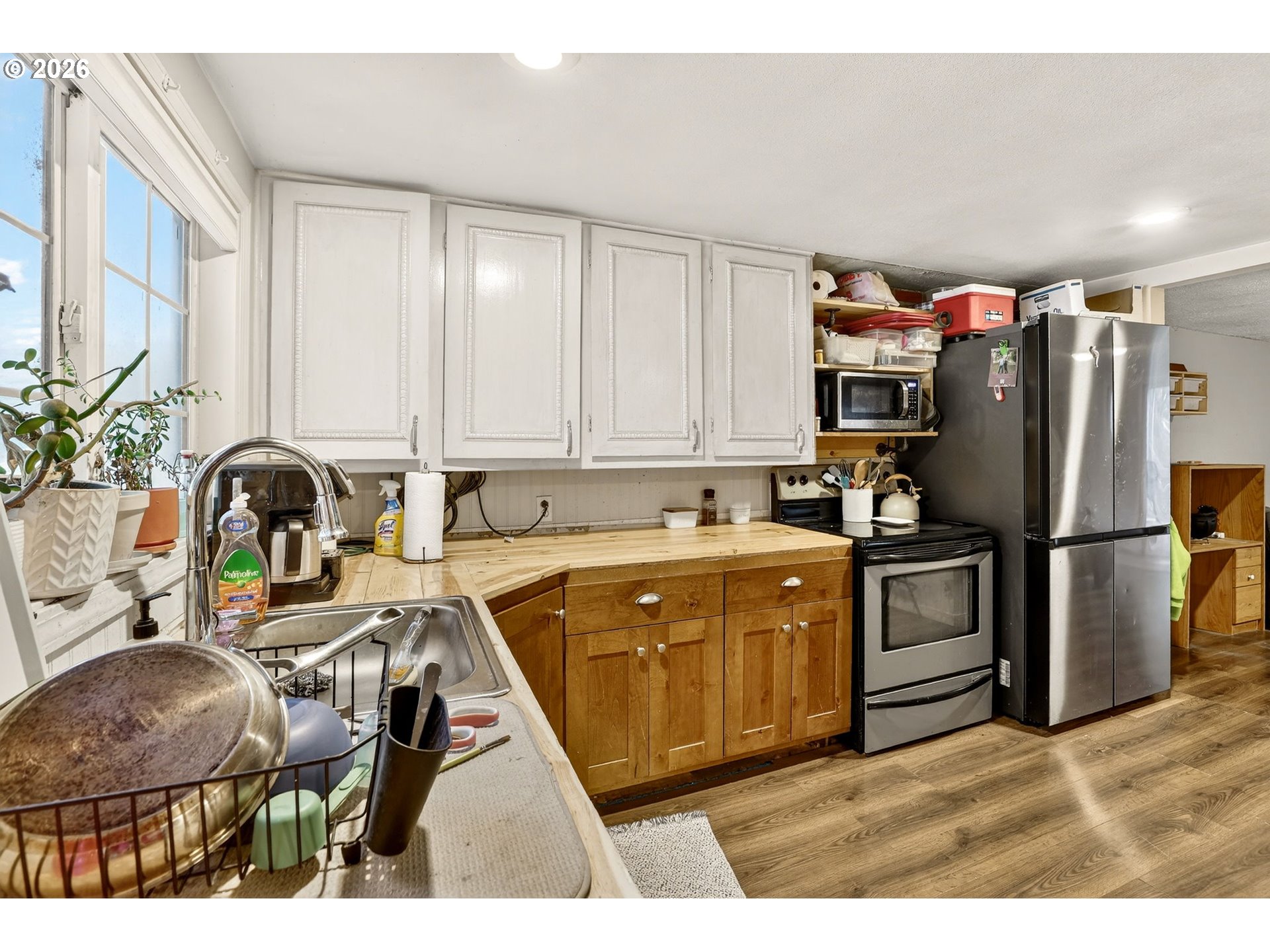 26200 Highway 211 Estacada, OR 97023 - Photo 10 of 24 a kitchen with stainless steel appliances a sink a stove a refrigerator cabinets and a dining table