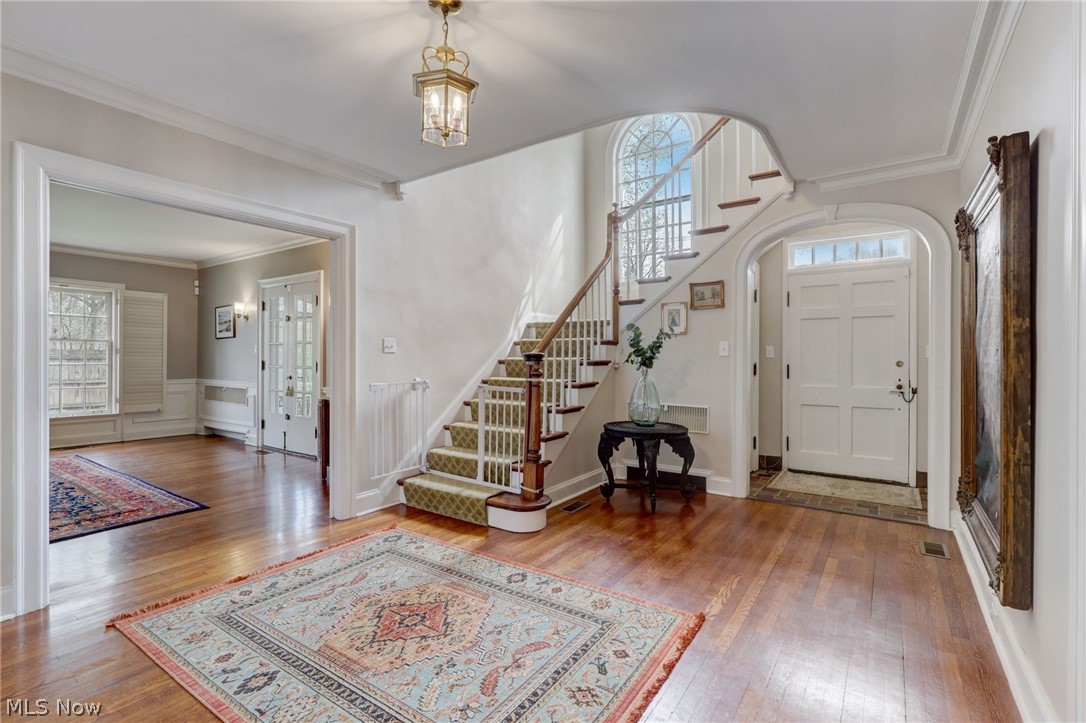 102 Wolcott Road Akron, OH 44313 - Photo 7 of 48 Entrance foyer featuring an inviting chandelier, crown molding, and wood flooring