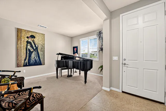 a view of a dining room with furniture a chandelier and large windows