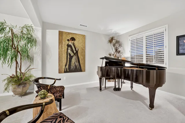 a dining room with wooden floor a chandelier a wooden table and chairs