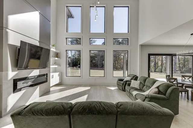 a large kitchen with stainless steel appliances kitchen island granite countertop a table chairs in it and wooden floors