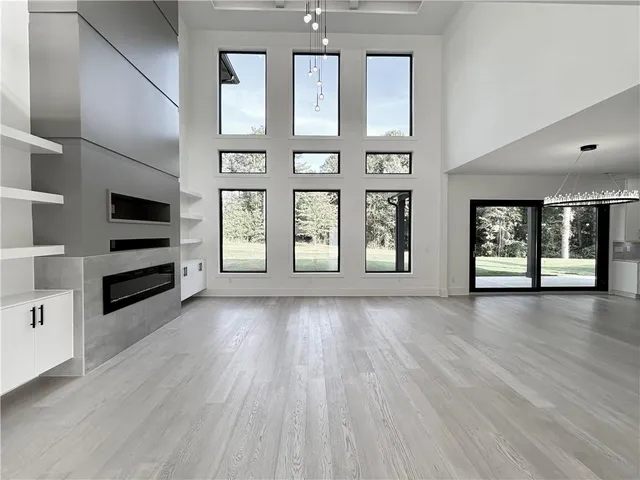 a kitchen with a stove a sink a refrigerator and white cabinets with wooden floor