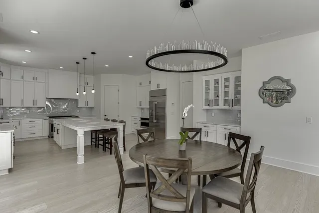 a view of an empty room with a window and a kitchen