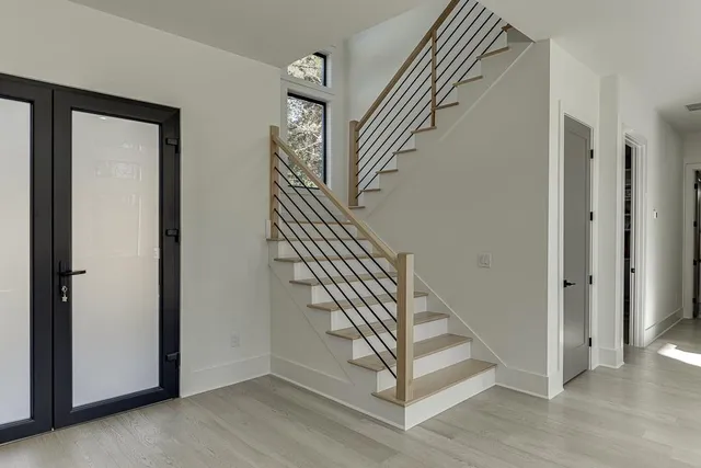 a view of a hallway with wooden floor and a living room