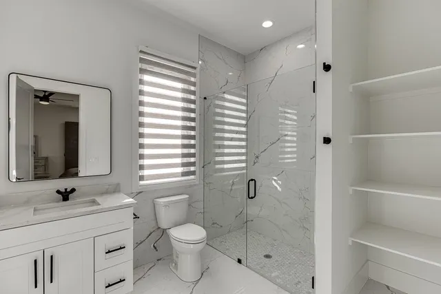 a bathroom with a sink a toilet and shower