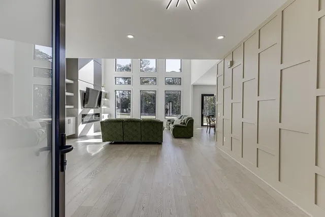 a living room with furniture a large window and a walk in closet
