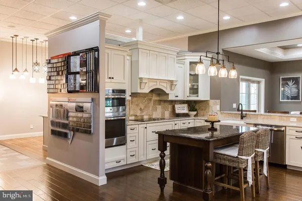 a kitchen with kitchen island a stove a sink and a microwave