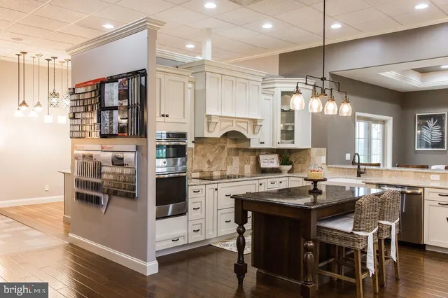 a kitchen with kitchen island a stove a sink and a microwave