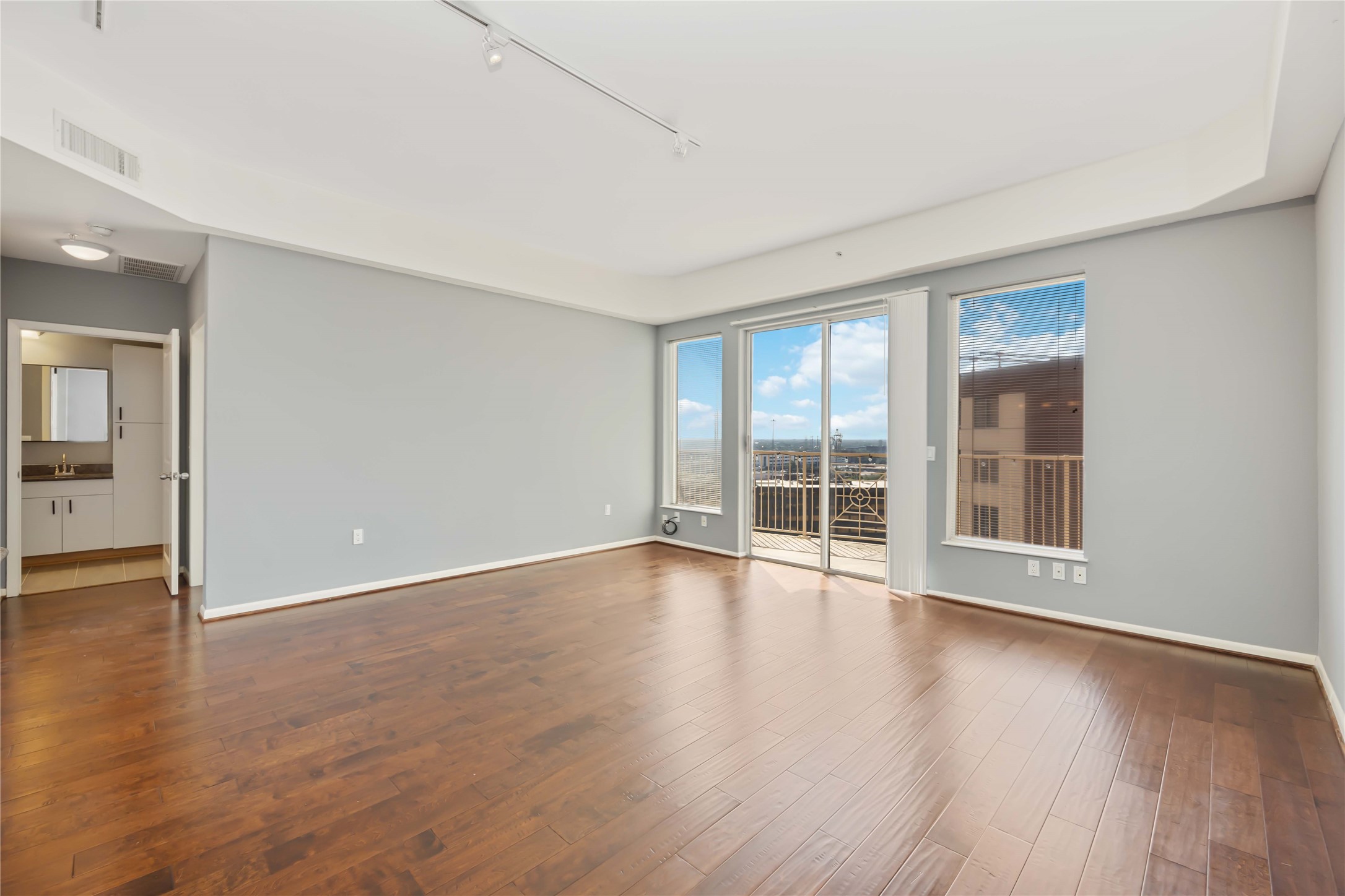 3505 Sage Road, Unit 1508 Houston, TX 77056 - Photo 5 of 23 Relax in the spacious formal living area featuring high ceilings, vinyl plank flooring, and sliding glass doors that lead out to a private balcony space.