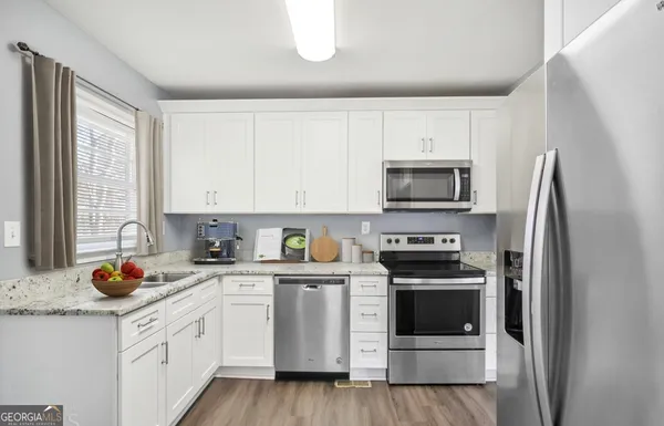 a kitchen with white cabinets and stainless steel appliances