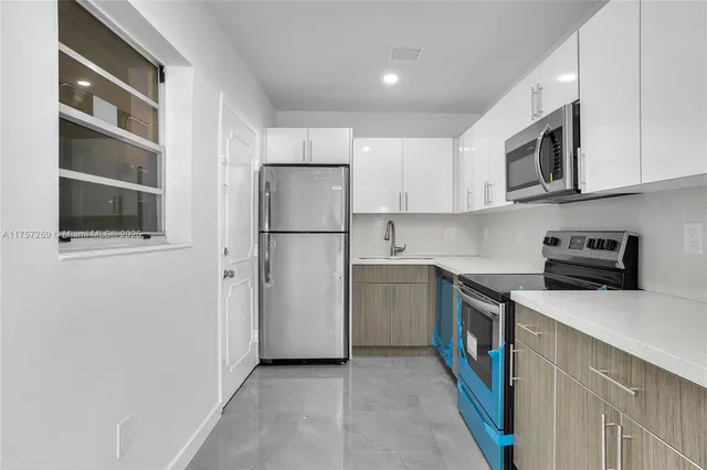 a kitchen with stainless steel appliances white cabinets and a refrigerator