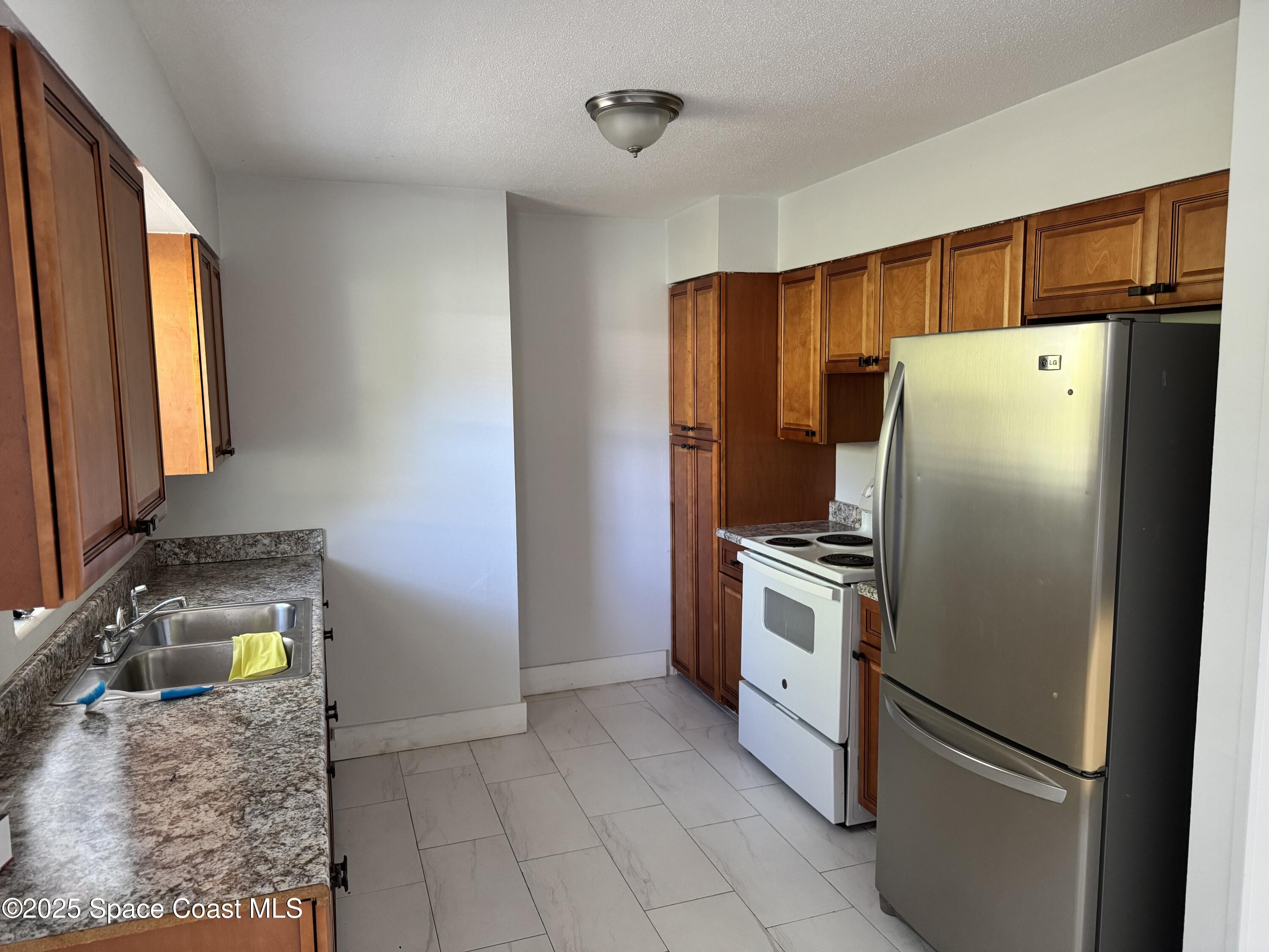 116 E Avenue Melbourne, FL 32901 - Photo 5 of 9 a kitchen with stainless steel appliances granite countertop a refrigerator and a sink