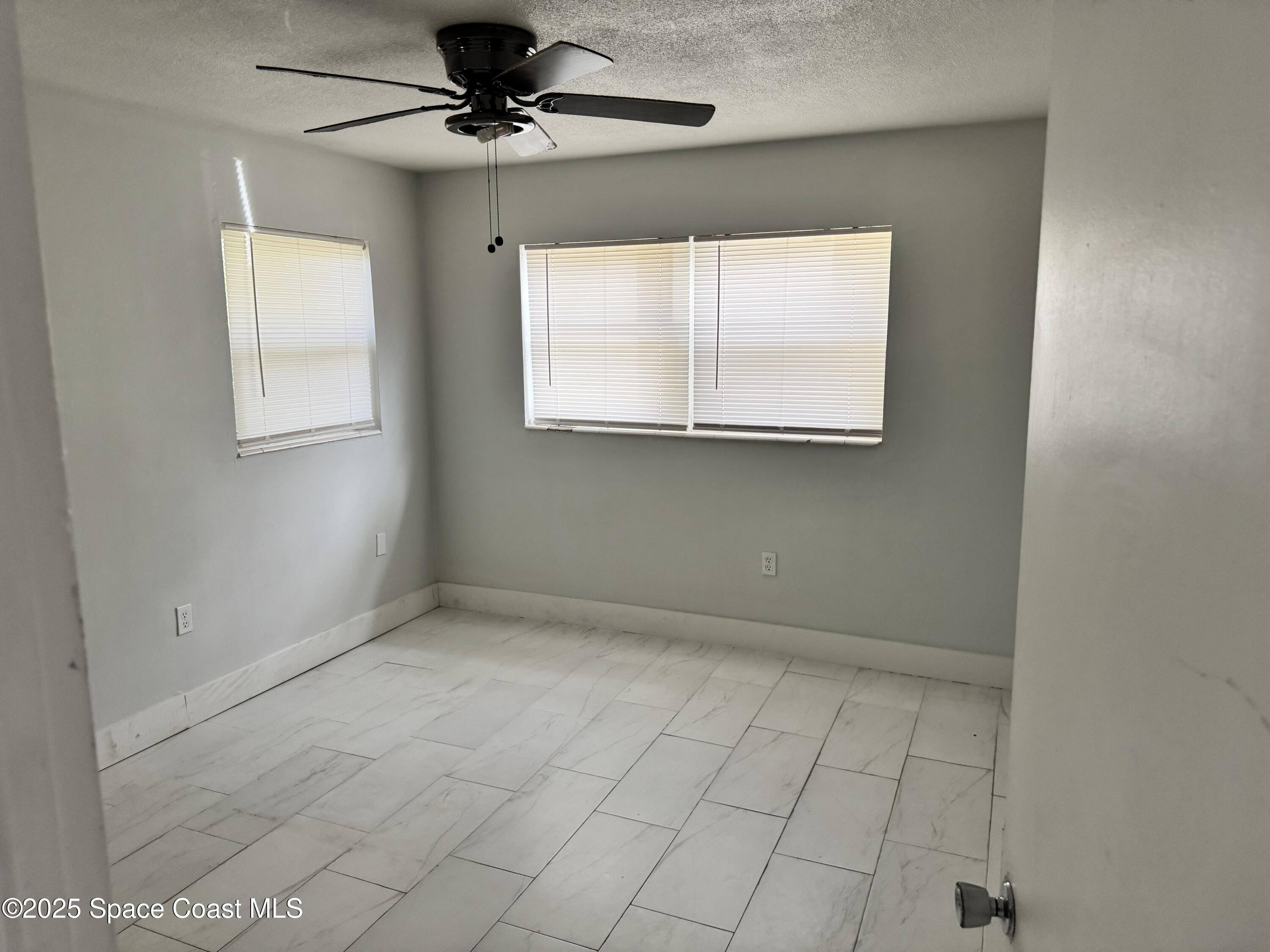 116 E Avenue Melbourne, FL 32901 - Photo 8 of 9 an empty room with windows and fan