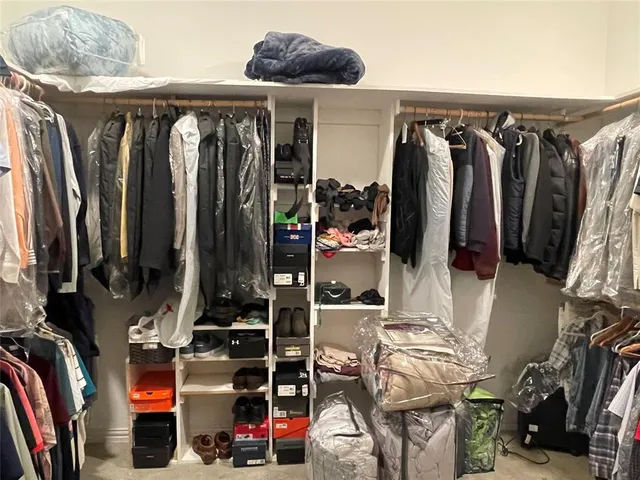 a view of walk in closet with clothes and shoes