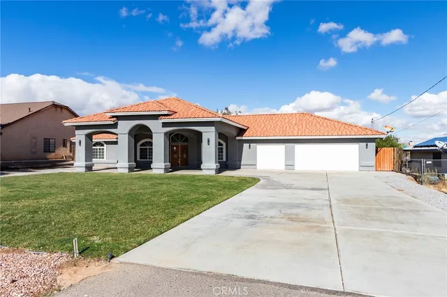 a front view of a house with a garden and yard