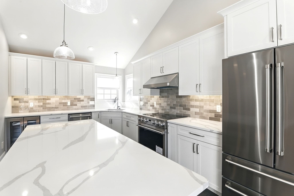 5 Bennett Road Hampden, MA 01036 - Photo 14 of 42 a kitchen with stainless steel appliances kitchen island granite countertop a refrigerator a sink dishwasher a stove and white cabinets with wooden floor