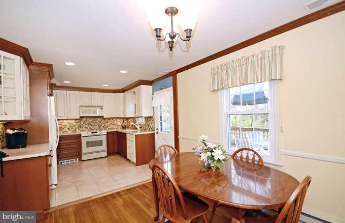 4453 Carroll Manor Road Baldwin, MD 21013 - Photo 11 of 30 a kitchen with a table chairs stove and refrigerator