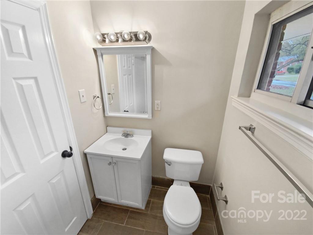 3209 Credenza Road Charlotte, NC 28208 - Photo 19 of 20 a bathroom with a toilet sink and mirror