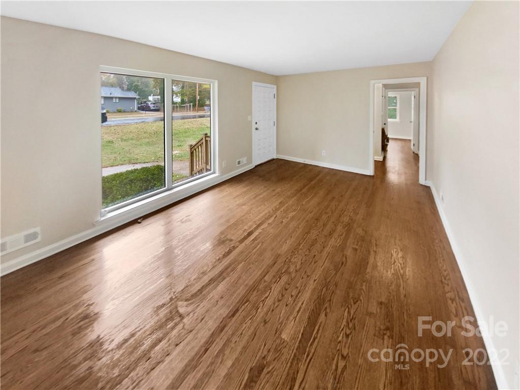 3209 Credenza Road Charlotte, NC 28208 - Photo 3 of 20 wooden floor in an empty room with a window