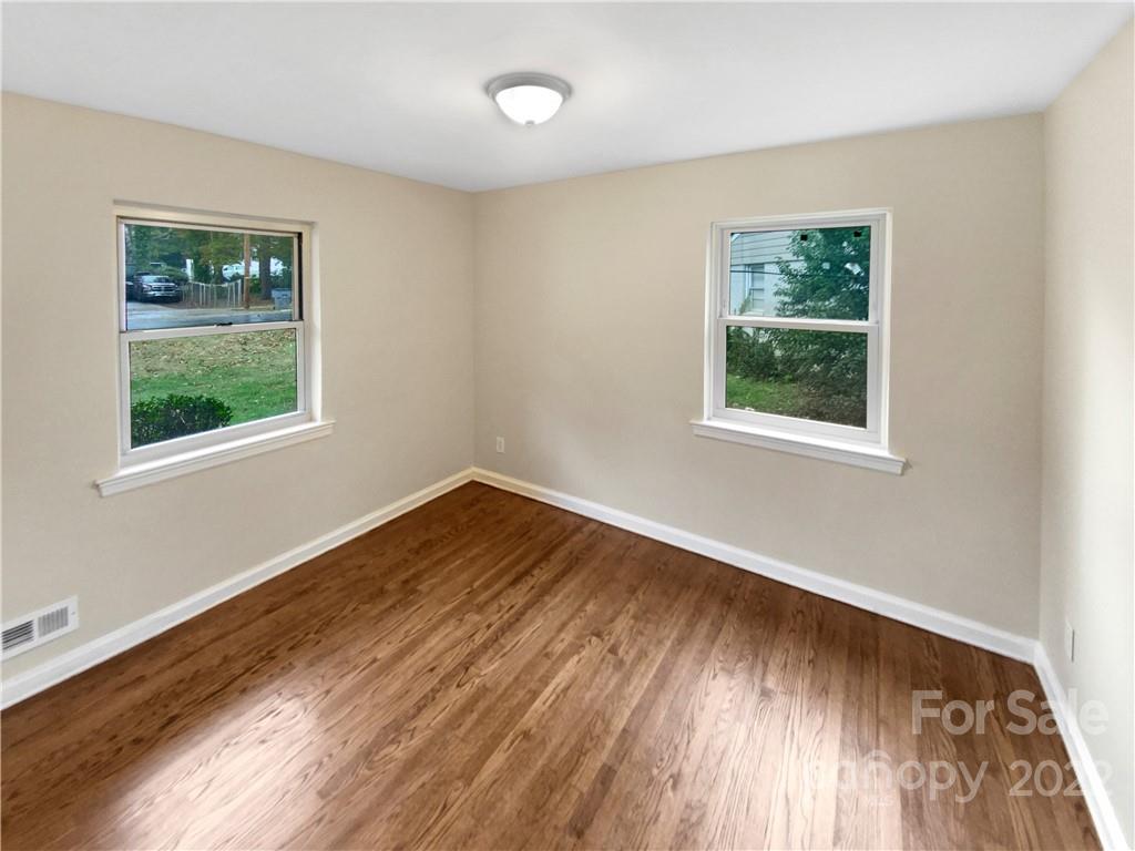 3209 Credenza Road Charlotte, NC 28208 - Photo 5 of 20 a view of an empty room with wooden floor and a window