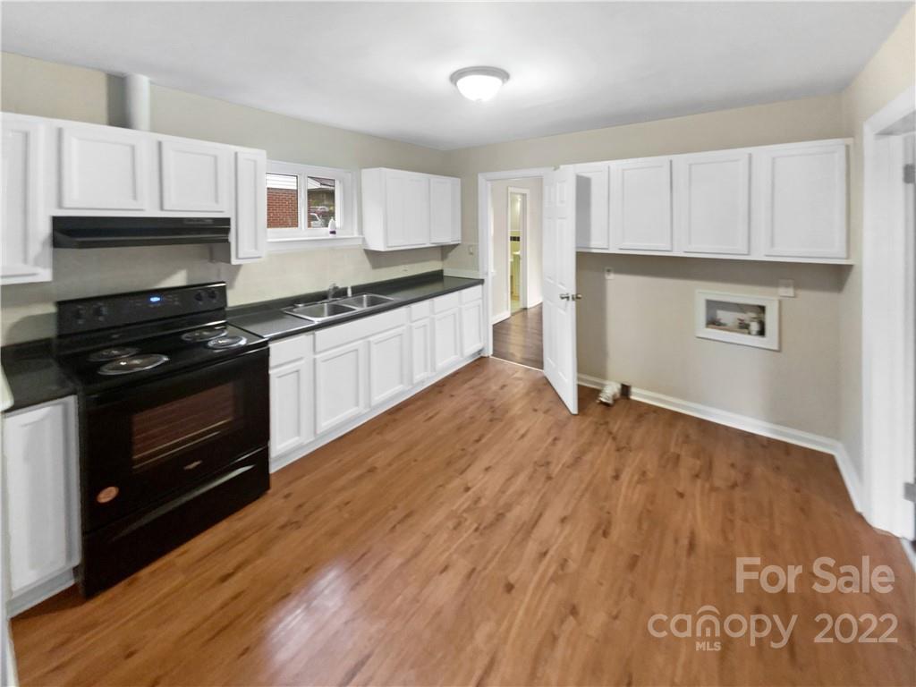 3209 Credenza Road Charlotte, NC 28208 - Photo 6 of 20 a kitchen with granite countertop a stove top oven and cabinets