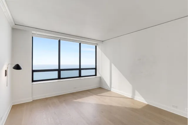 a view of a room with wooden floor and a bathroom