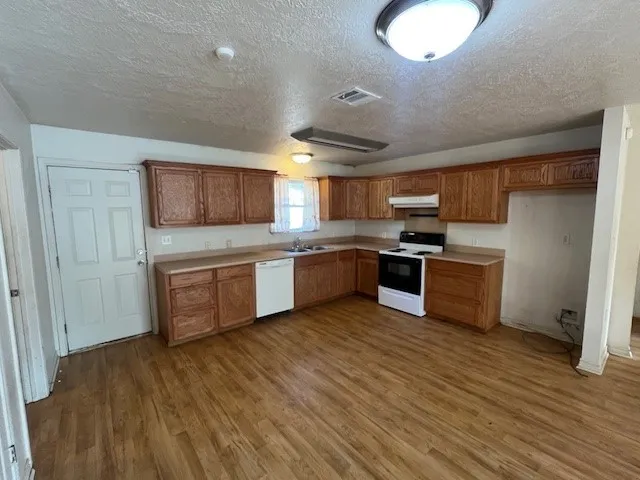 a kitchen with stainless steel appliances granite countertop a stove sink and cabinets