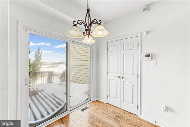 a view of a hallway with wooden floor and a dining room view