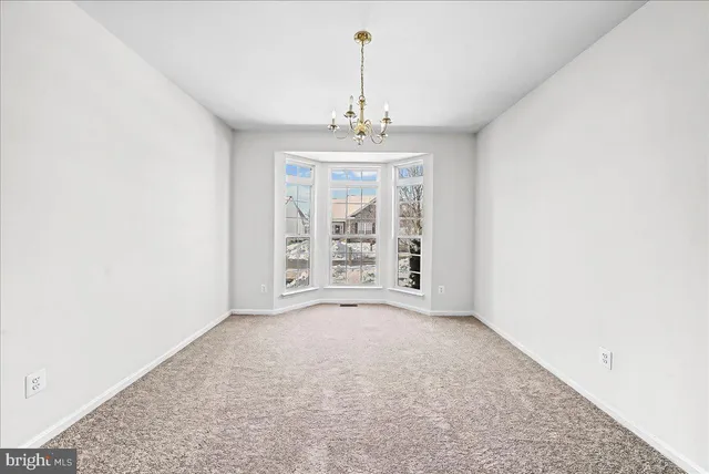 an empty room with windows and cabinet