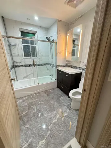 a bathroom with a sink a toilet a mirror and bathtub