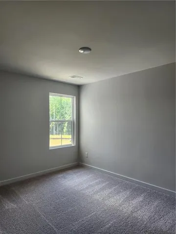 a view of a hallway to a livingroom and a bathroom