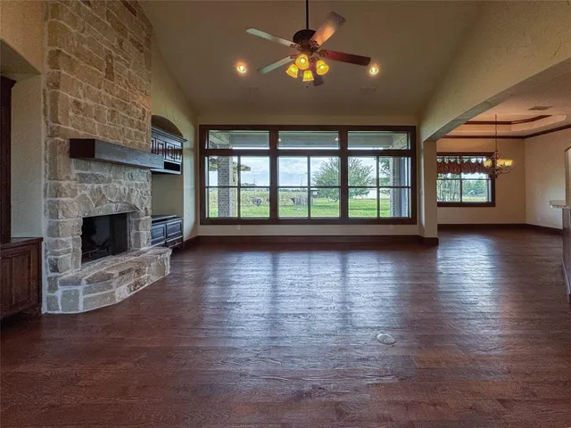 an empty room with floor to ceiling windows and a fireplace