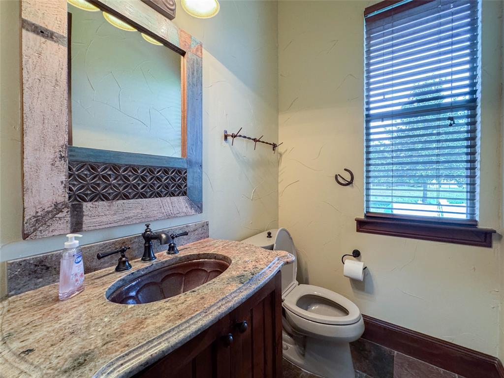 1559 East Blackjack Road East Pilot Point, TX 76258 - Photo 12 of 40 a bathroom with a granite countertop sink toilet and mirror