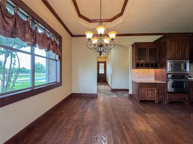 a view of a livingroom with furniture wooden floor and chandelier