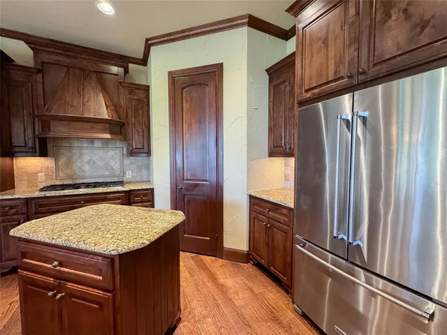 a kitchen with granite countertop a refrigerator and a sink