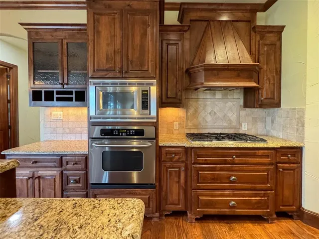 a kitchen with granite countertop a stove and a wooden cabinets