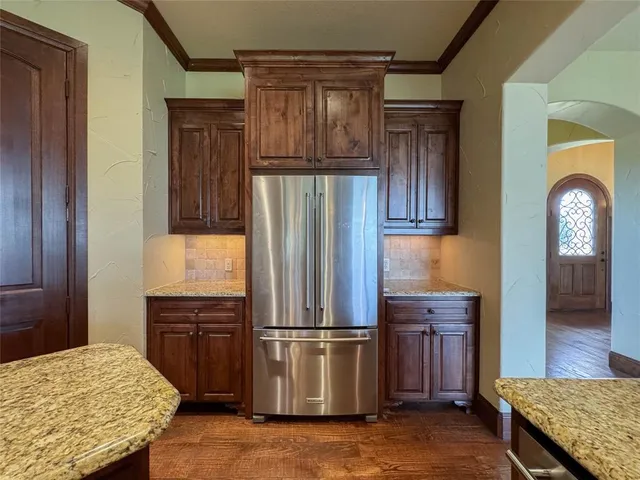 a kitchen with stainless steel appliances granite countertop a refrigerator and a stove
