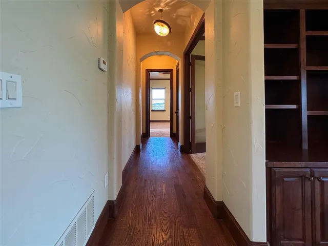 a view of a hallway with wooden floor and closet