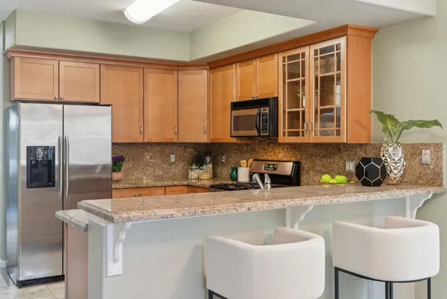 a kitchen with stainless steel appliances granite countertop a sink stove and refrigerator
