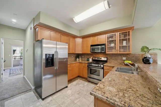 a kitchen with stainless steel appliances granite countertop a refrigerator stove and sink