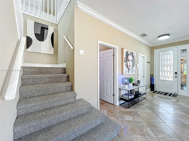 a spacious bedroom with a bed a window and potted plant