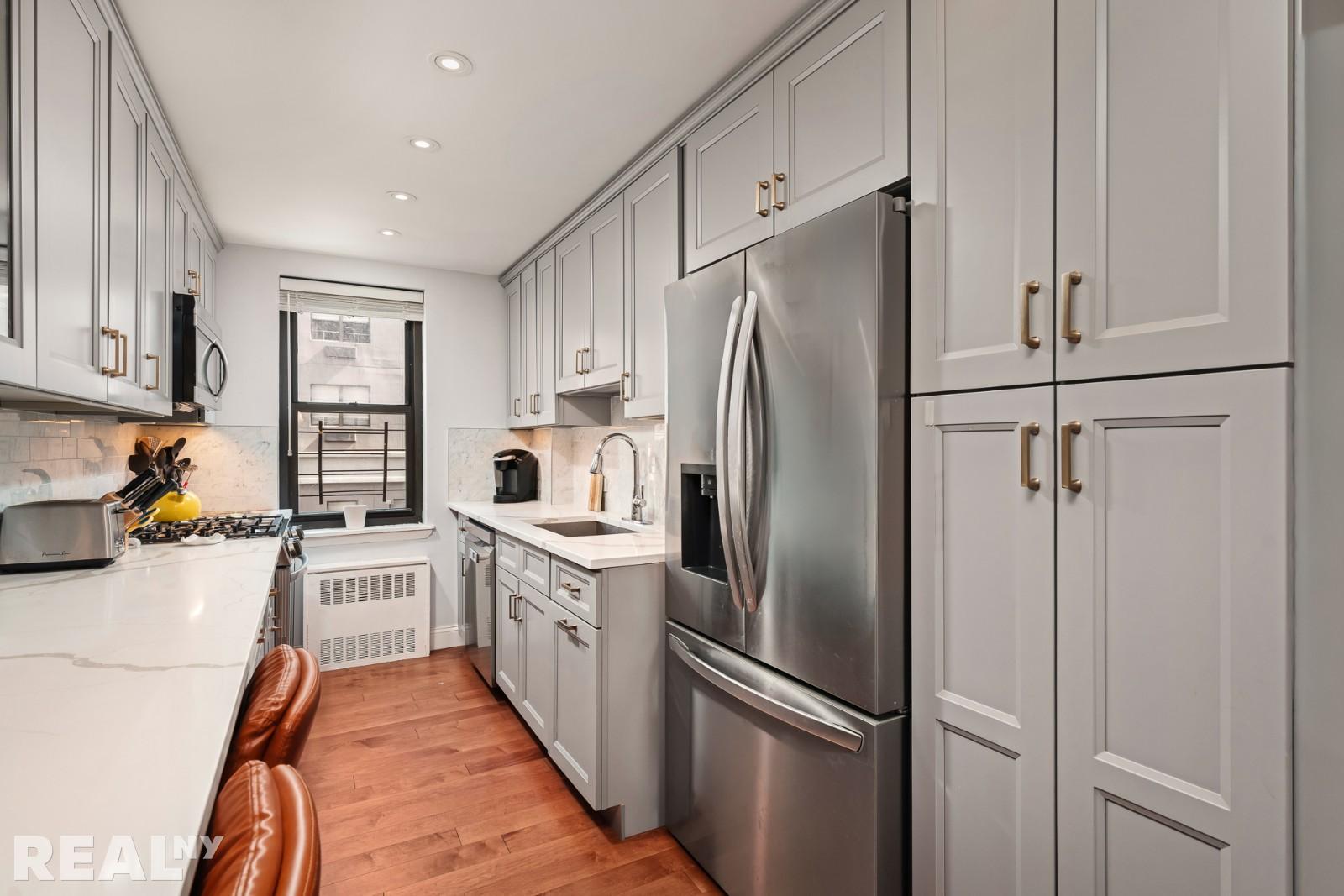 200 East 24th Street, Unit 706 Manhattan, NY 10010 - Photo 11 of 17 a kitchen with stainless steel appliances a refrigerator sink and cabinets