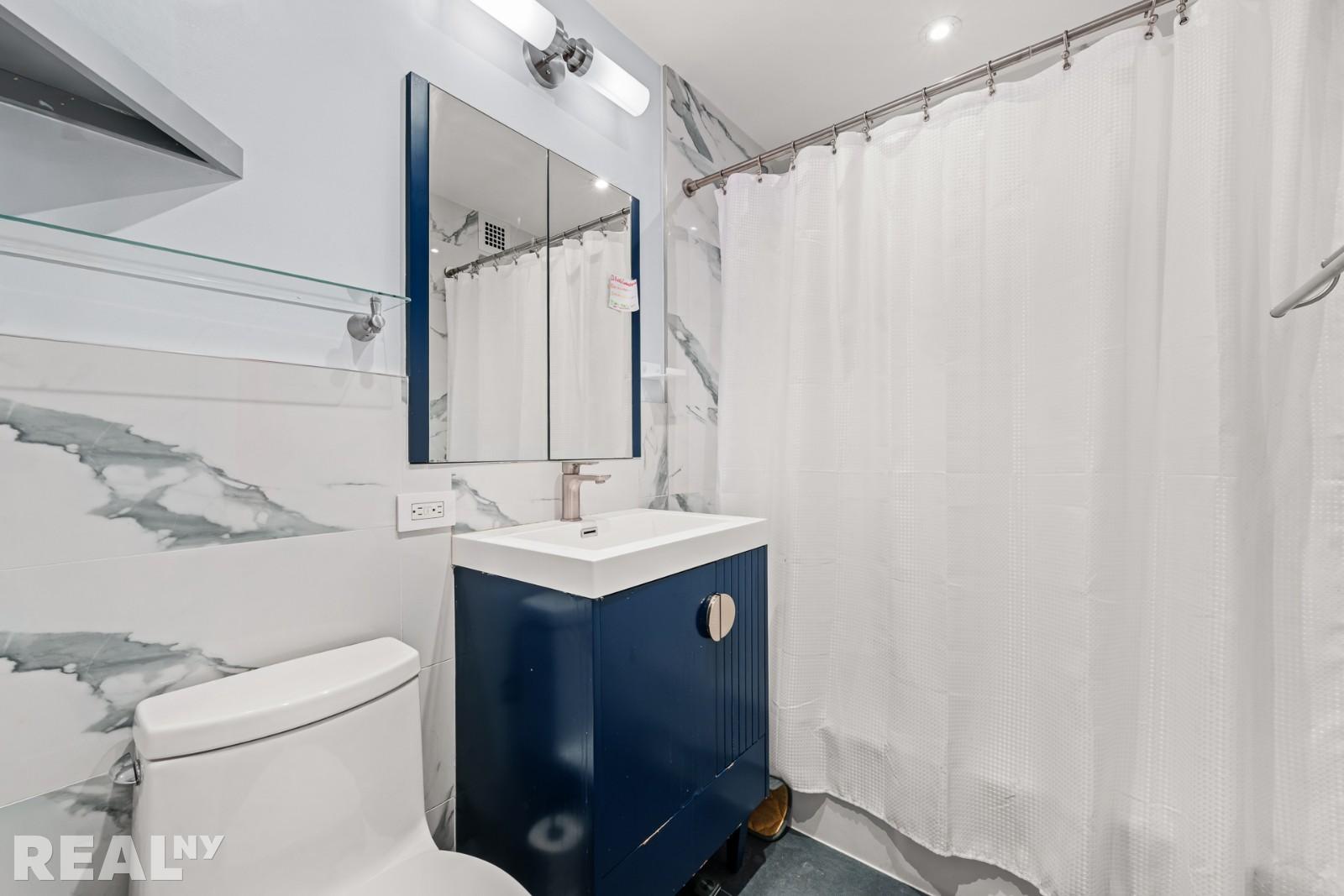 200 East 24th Street, Unit 706 Manhattan, NY 10010 - Photo 12 of 17 a bathroom with a sink a toilet and shower