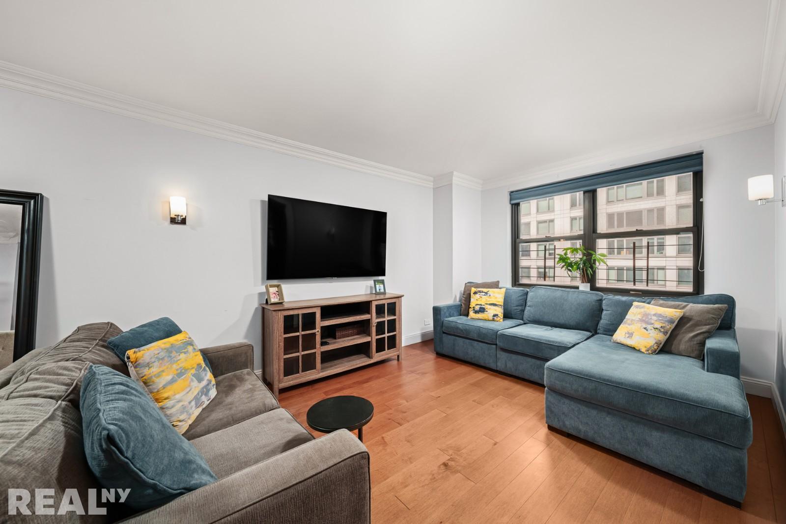 200 East 24th Street, Unit 706 Manhattan, NY 10010 - Photo 2 of 17 a living room with furniture and a flat screen tv