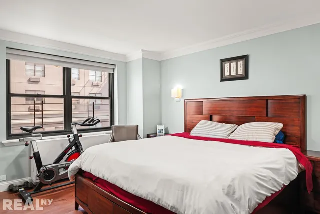 a bed sitting in a bedroom next to a window